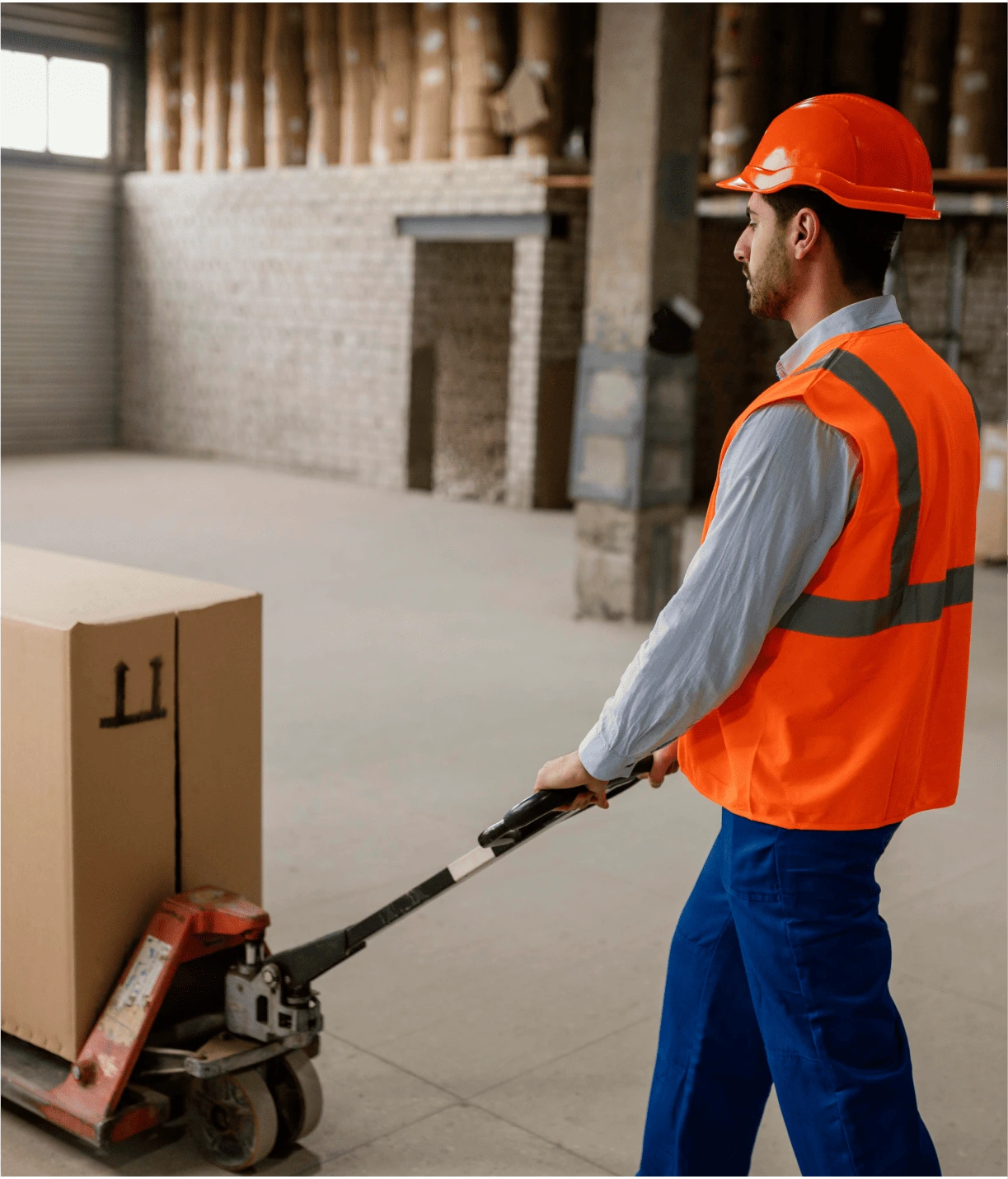 Homme en tenue orange en train de déplacer une palette